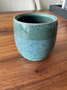 a blue bowl sitting on top of a wooden table