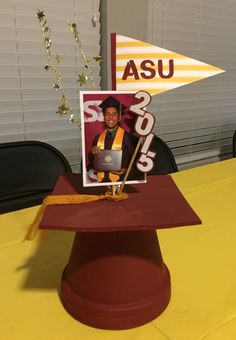 a graduate's cap and diploma on top of a table with a photo in the center