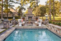 an outdoor fireplace and seating area next to a swimming pool