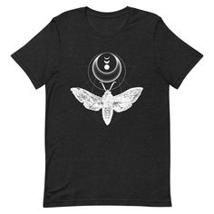 The moth represents optimism, always seeking light in the darkness. This insect t-shirt makes the perfect gift for a nature lover! It features my original graphic design work using a vintage moth sketch.  This lightweight t-shirt is soft and just the right amount of stretch. It's flattering and comfortable for both men and women. My t-shirts are designed by me and made/shipped by my production partner. Size guide: Length (inches) S: 28 M: 29 L: 30 XL: 31 2XL: 32 3XL: 33 4XL: 34 Width (inches) S: 18 M: 20 L: 22 XL: 24 2XL: 26 3XL: 28 4XL: 30 SHIPPING LOCATIONS I work with a production partner to have my artwork made-to-order on t-shirts, prints, and more. When you place an order it will be sent to one of their fulfillment centers dependent on product type, availability, and shipping locatio Moth Sketch, Witchy Tshirt, Wiccan Shirt, The Tower Tarot Card, The Tower Tarot, Graphic Design Work, Light In The Darkness, The Moth, Boho Cottage