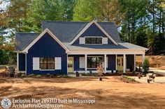 a blue house with white trim and windows in the front yard is surrounded by trees