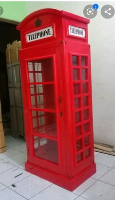 a red phone booth sitting on top of a tiled floor