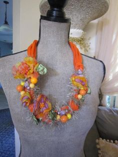 a mannequin with an orange necklace on it