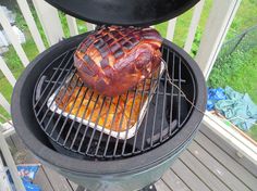 there is a large roasting pan on top of the grill with food cooking in it