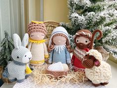 crocheted nativity figurines are displayed in front of a christmas tree