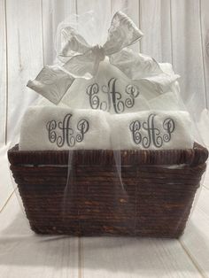 two monogrammed towels in a basket with bow