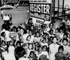 a group of children standing next to each other in front of a sign