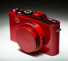 a red digital camera sitting on top of a table