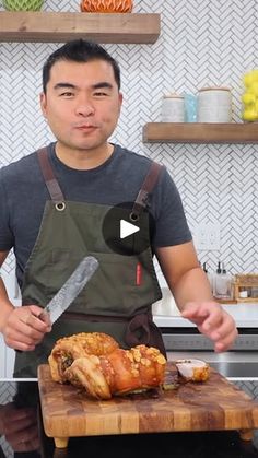 a man standing in front of a wooden cutting board with a turkey on top of it