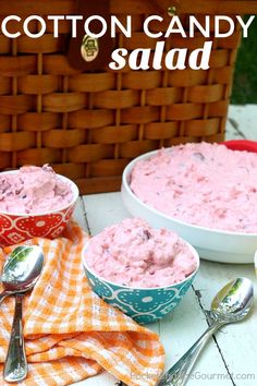 two bowls of cotton candy salad on a picnic table with spoons and orange towels