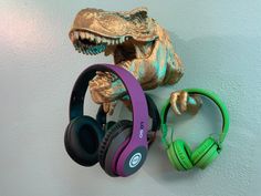 headphones are hanging on the wall next to a dinosaur