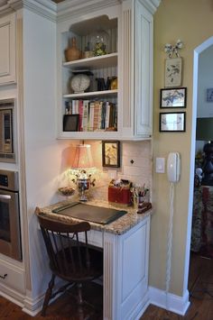 a kitchen with an oven, microwave and desk in the corner next to it is also a dining room