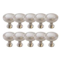 six white knobs with gold trim on them