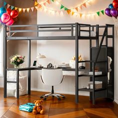 a loft bed with a desk underneath it and balloons hanging from the ceiling behind it