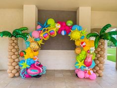 an arch made out of balloons and palm trees