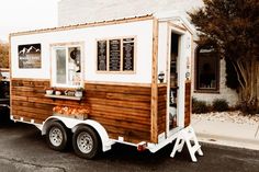 a small food truck is parked on the side of the road