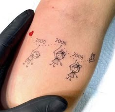 a person with a small tattoo on their arm that has numbers and people drawn on it