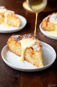 a piece of cake on a white plate being drizzled with icing