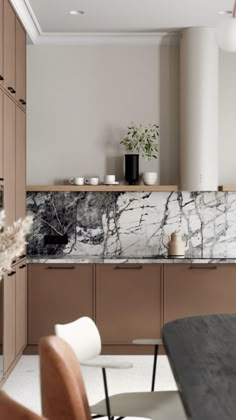 a kitchen with marble counter tops and wooden cabinetry, along with modern dining chairs