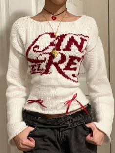 a woman wearing a white sweater with red letters on it