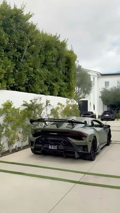 a grey sports car parked in front of a house