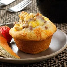 a muffin is on a plate with fruit