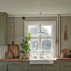 a kitchen filled with lots of counter top space next to a large white sink under a window