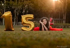 a woman laying in the grass with her number five balloon