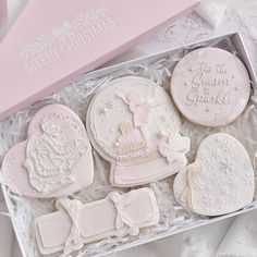 decorated cookies in a pink box on a table