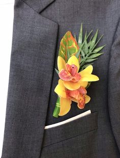 a boutonniere with yellow flowers and green leaves