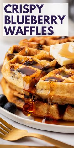 a stack of blueberry waffles on a plate with butter and syrup being drizzled over them