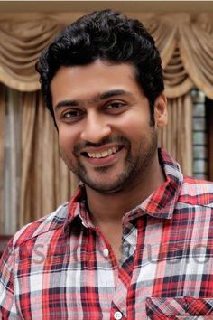 a smiling man in a red and white checkered shirt