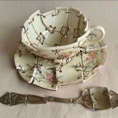 an antique tea cup and saucer with matching spoons