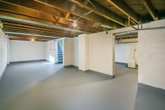 an empty room with white walls and exposed ceilings