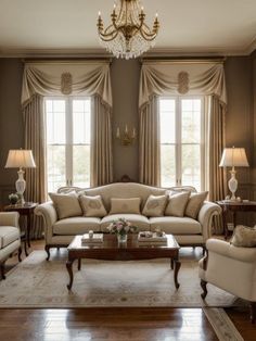 a living room with two couches, chairs and a coffee table in front of windows