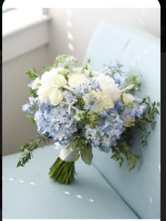 a bouquet of blue and white flowers sitting on a couch