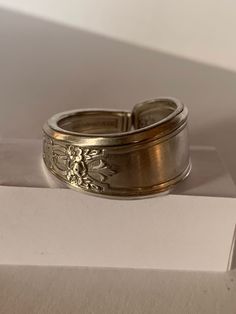 "Handcrafted from a vintage 1847 Rogers Bros silver plated spoon, this ring earns the \"Ambassador\" label through its intricate interwoven symbols representing many nations. Pictured here is a size 11. For other sizings, please ask! We'll try to find you a fit." Silver Etched Open Engraved Ring, Silver Engraved Open Ring With Etched Details, Engraved Silver Open Ring With Etched Details, Vintage Handmade Wide Band Jewelry, Handmade Vintage Wide Band Jewelry, Adjustable Engraved Antique Silver Ring, Handmade Vintage Open Engraved Ring, Antique Silver Engraved Ring, Vintage Sterling Silver Wide Band Jewelry