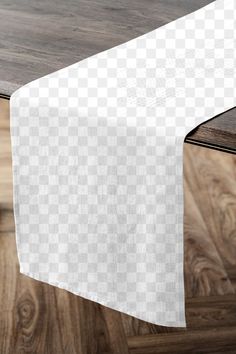 a white table cloth on top of a wooden table with wood flooring in the background