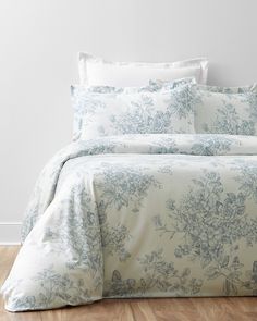 a bed with blue and white flowers on it