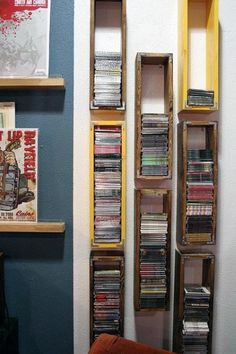 the shelves are filled with cd's and cds in wooden boxes on the wall