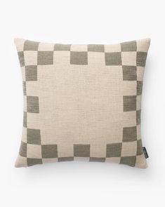 a beige and grey pillow with squares on it