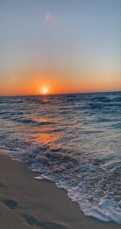 the sun is setting over the ocean with waves