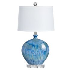 a blue and white lamp with a white shade on the top is sitting in front of a white background