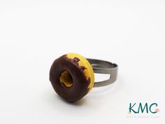 a doughnut ring with chocolate frosting and sprinkles sitting on a white surface