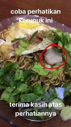 a plate filled with noodles and vegetables on top of a wooden table