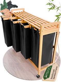 three black trash cans are attached to a wooden rack