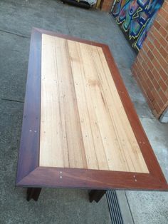 a wooden table sitting on top of a sidewalk