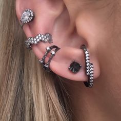 a woman wearing ear piercings with black and white stones