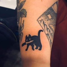 a black cat with a knife in it's mouth is on the arm of a person