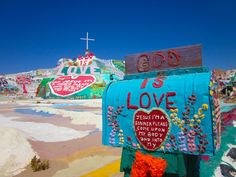 a blue mailbox with the word love written on it in front of a church